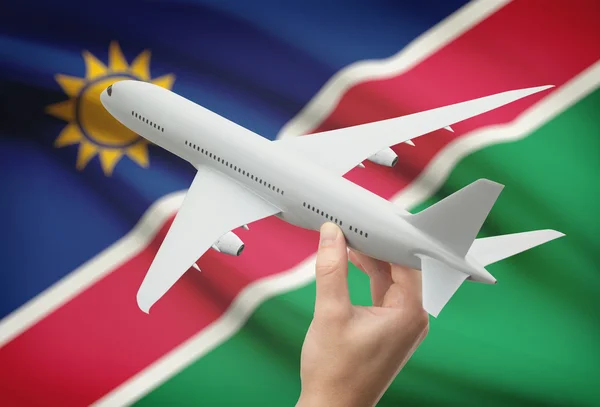 Airplane in hand with flag on background - Namibia — Stock Photo, Image