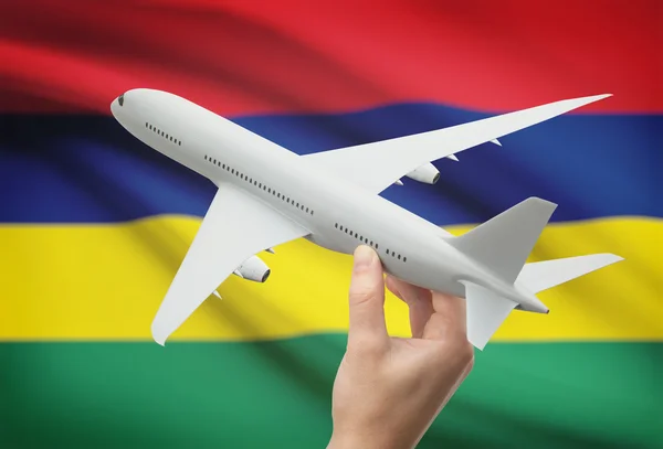 Airplane in hand with flag on background - Mauritius — Stock Photo, Image