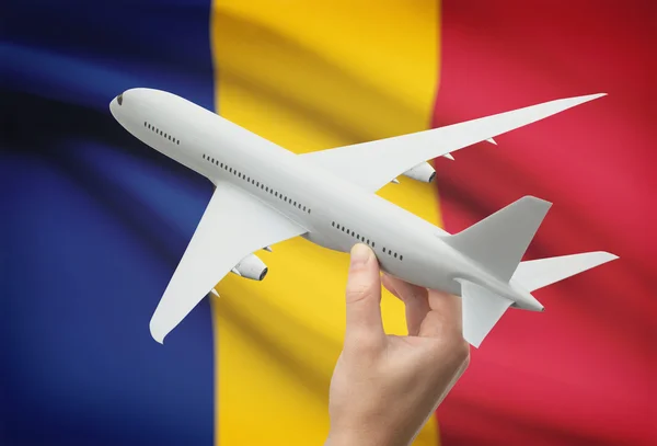 Airplane in hand with flag on background - Romania — Stock Photo, Image