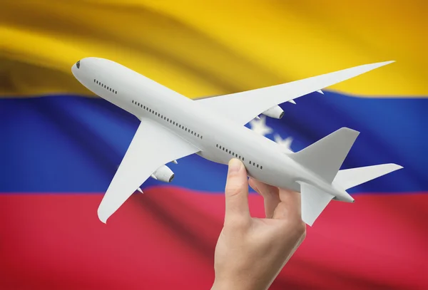 Самолет в руку с флагом на фоне - Венесуэла — стоковое фото