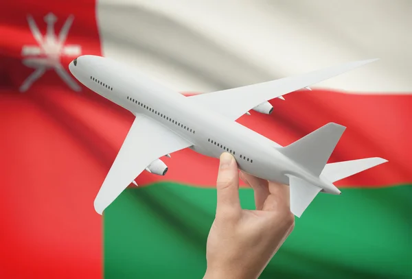 Vliegtuig in hand met vlag op achtergrond - Oman — Stockfoto