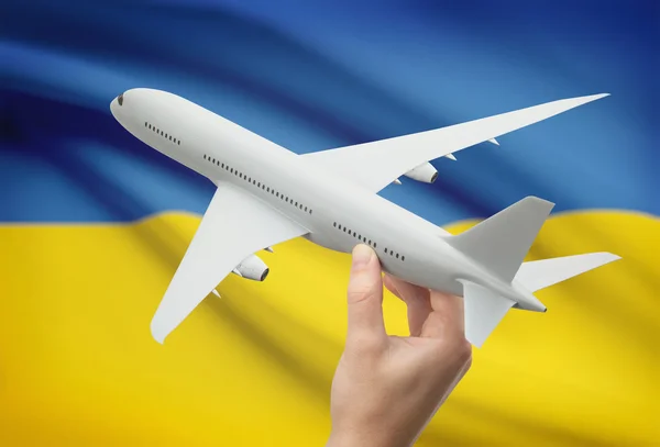 Flugzeug in der Hand mit Flagge auf Hintergrund - Ukraine — Stockfoto