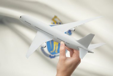 Airplane in hand with US state flag on background - Massachusetts