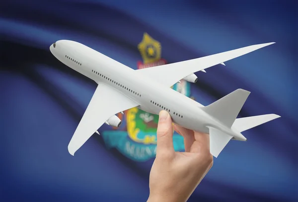 Самолет в руке с нами государственный флаг на фоне - Мэн — стоковое фото