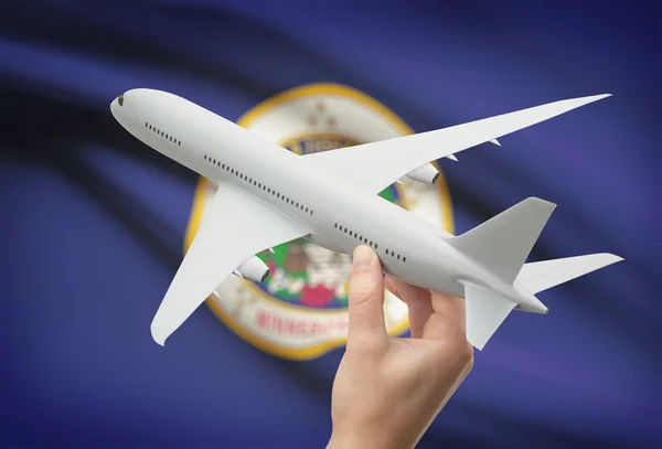 Airplane in hand with US state flag on background - Minnesota — Stock Photo, Image