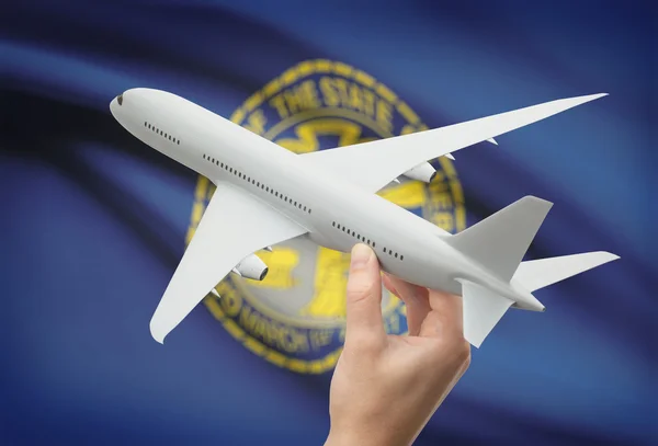 Airplane in hand with US state flag on background - Nebraska — ストック写真