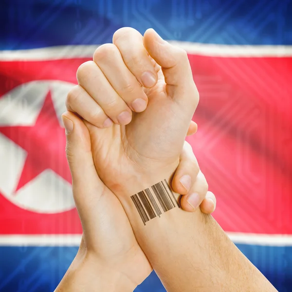 Barcode ID number on wrist and national flag on background series - North Korea — Stock Photo, Image