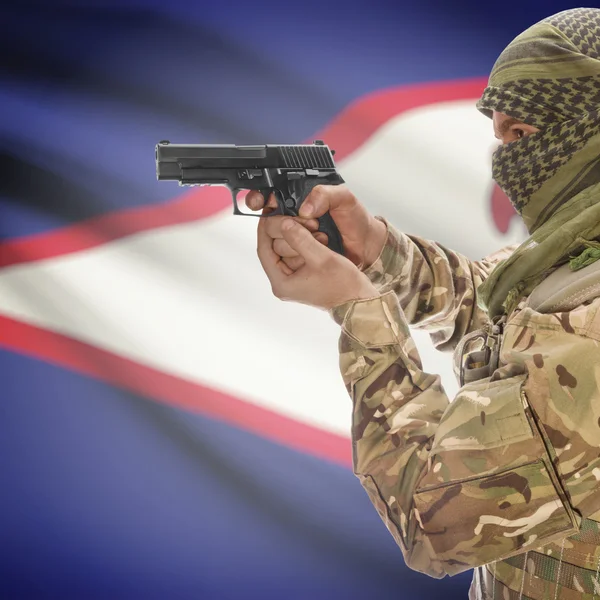 Male with gun in hands and national flag on background - American Samoa — Stok Foto