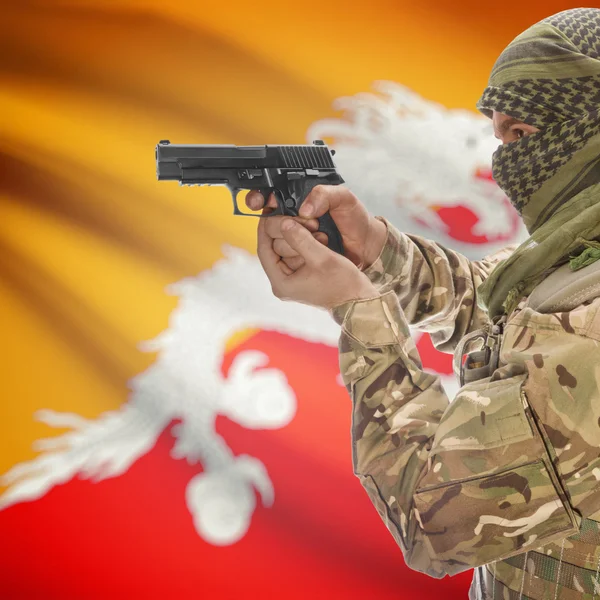 Мужчина с пистолетом в руках и национальный флаг на фоне - Бутан — стоковое фото