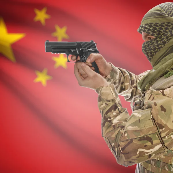 Uomo con la pistola nelle mani e bandiera nazionale su priorità bassa - Cina — Foto Stock