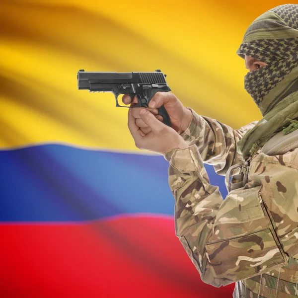 Männchen mit Gewehr in Händen und Nationalflagge auf Hintergrund - Kolumbien — Stockfoto