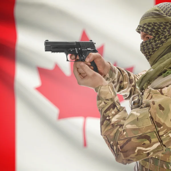 Male with gun in hands and national flag on background - Canada — Stok Foto