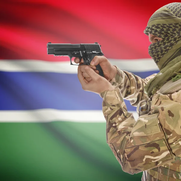 Чоловіки з пістолетом у руках і Національний прапор на фоні - Гамбія — стокове фото