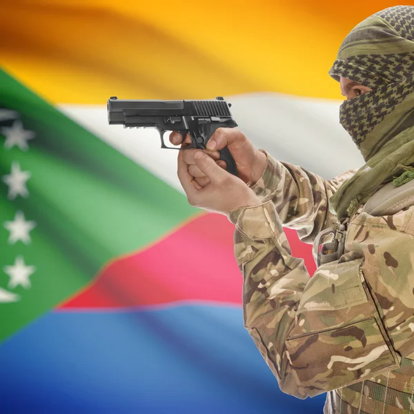 Чоловіки з пістолетом у руках і Національний прапор на фоні - Коморських островів — стокове фото