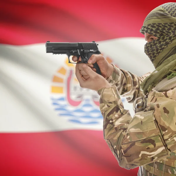 Hombre con pistola en las manos y la bandera nacional de fondo - Polinesia francesa —  Fotos de Stock