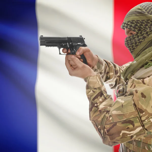 Male with gun in hands and national flag on background - France — Stok Foto