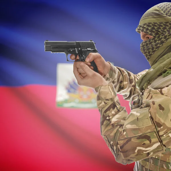 Male with gun in hands and national flag on background - Haiti — Stock Photo, Image