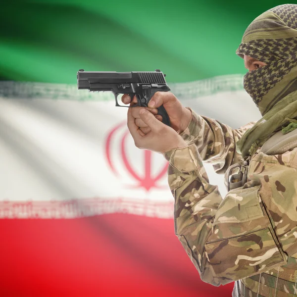 Male with gun in hands and national flag on background - Iran — Stok Foto