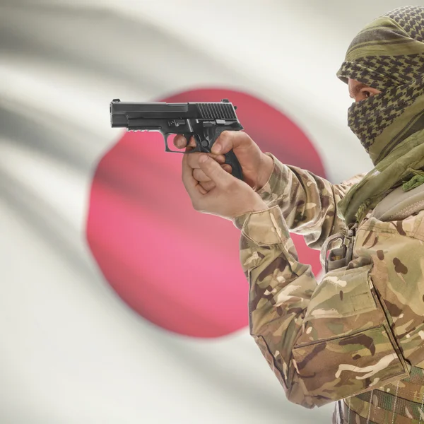 Male with gun in hands and national flag on background - Japan — Stok Foto