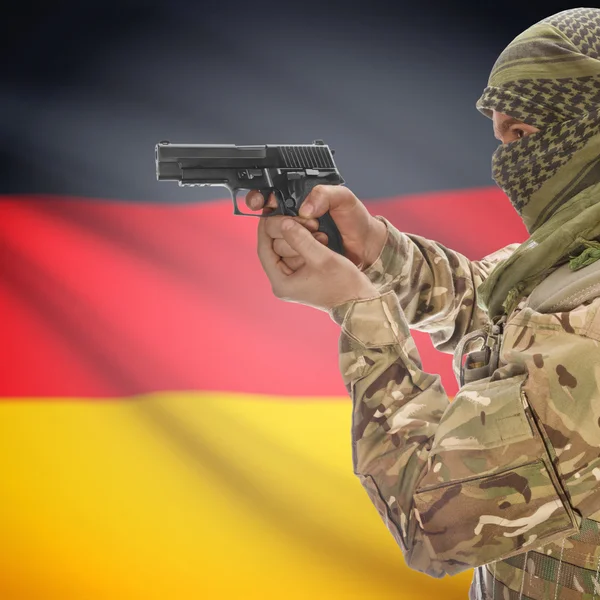 Male with gun in hands and national flag on background - Germany — Stok Foto
