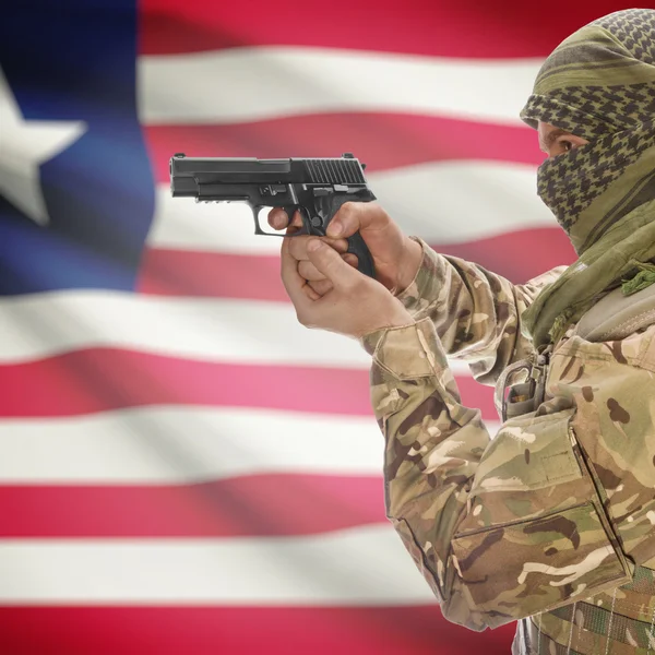Hane med pistol i händerna och nationella flagga på bakgrund - Liberia — Stockfoto