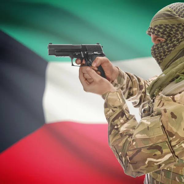 Male with gun in hands and national flag on background - Kuwait — Stok Foto