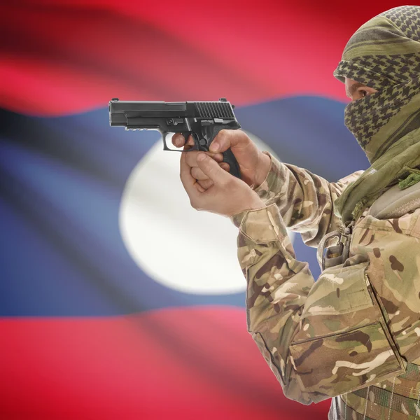 Male with gun in hands and national flag on background - Laos — Stok Foto