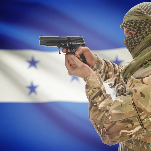 Male with gun in hands and national flag on background - Honduras — Stok Foto