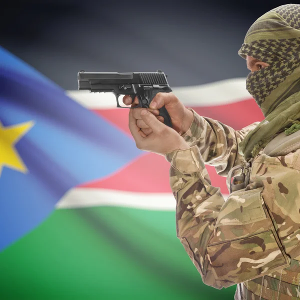 Мужчина с пистолетом в руках и национальный флаг на фоне - Южный Судан — стоковое фото