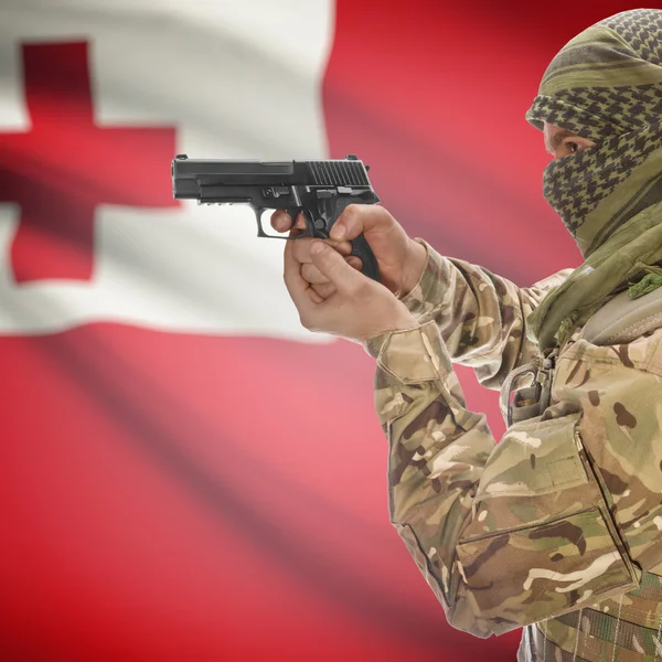 Male with gun in hands and national flag on background - Tonga — Stok Foto