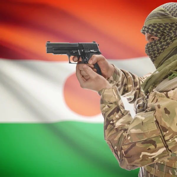 Férfi pisztollyal a kezében és a háttér - Niger zászlaja — Stock Fotó