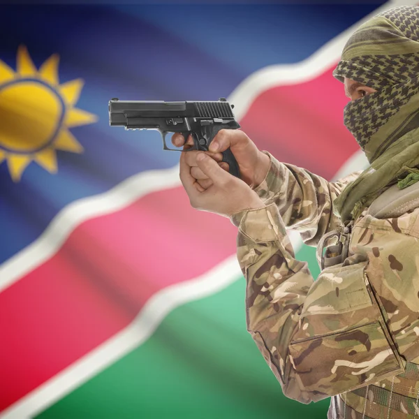 Männchen mit Gewehr in Händen und Nationalflagge auf Hintergrund - Namibia — Stockfoto