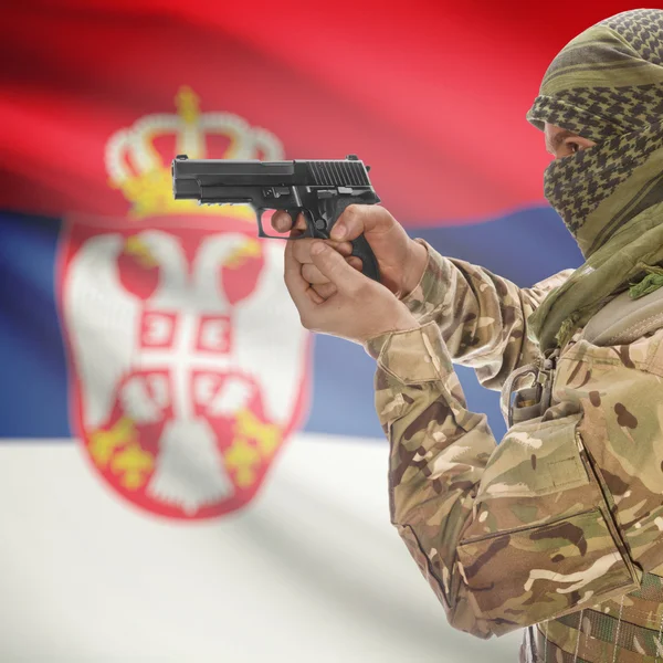 Male with gun in hands and national flag on background - Serbia — Stok Foto