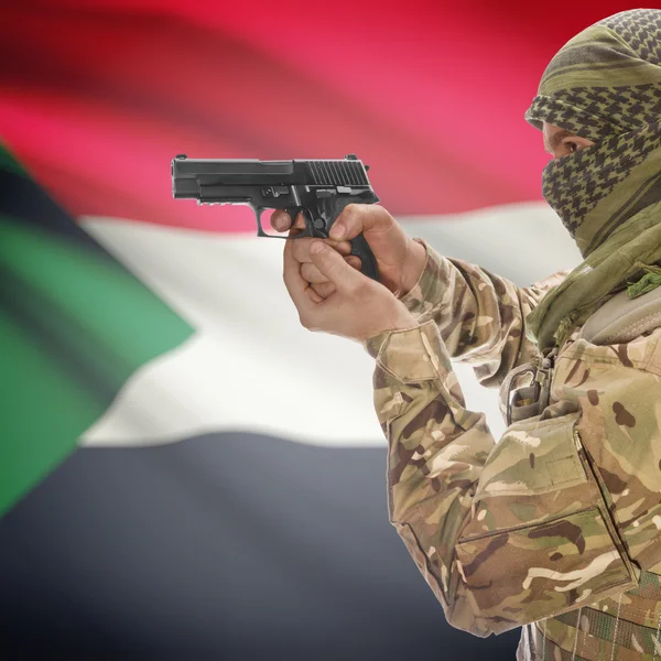 Male with gun in hands and national flag on background - Sudan — Stok Foto