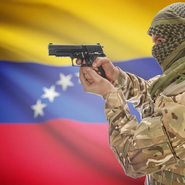 Male with gun in hands and national flag on background - Venezuela — Stock Photo, Image