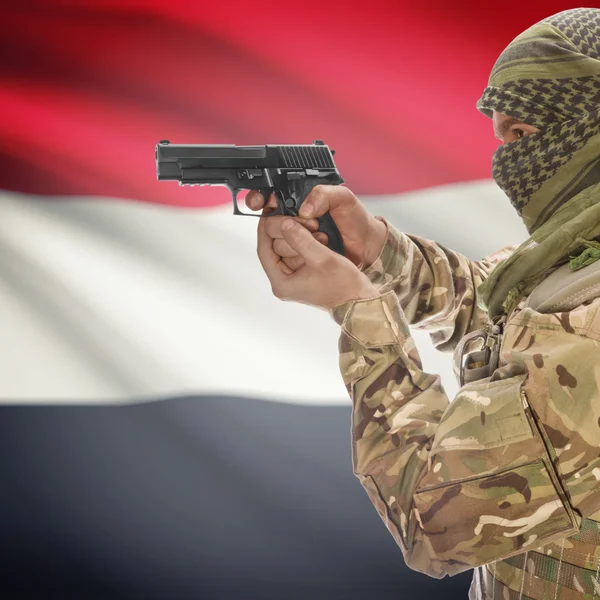 Male with gun in hands and national flag on background - Yemen — Stock Photo, Image