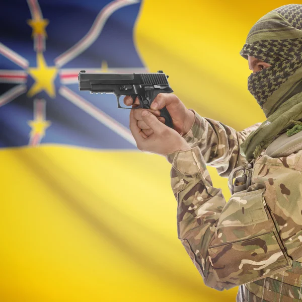 Male with gun in hands and national flag on background - Niue — Stockfoto