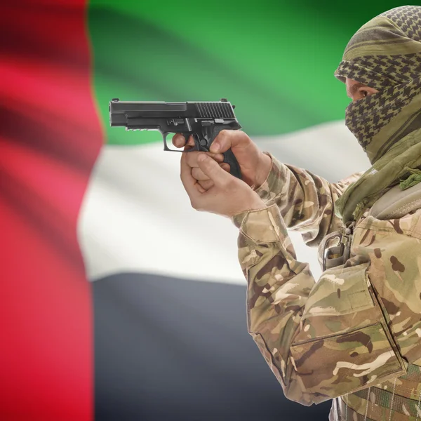 Male with gun in hands and national flag on background - United Arab Emirates — Stock Fotó