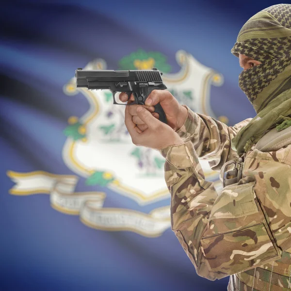 Мужчина с пистолетом в руках и государственный флаг США на фоне серии - Коннектикут — стоковое фото