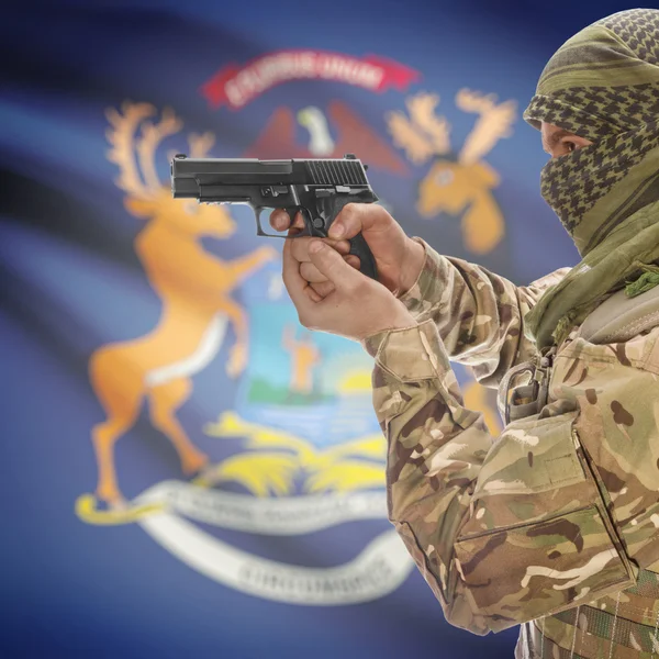 Male with gun in hands and USA state flag on background series - Michigan — стокове фото