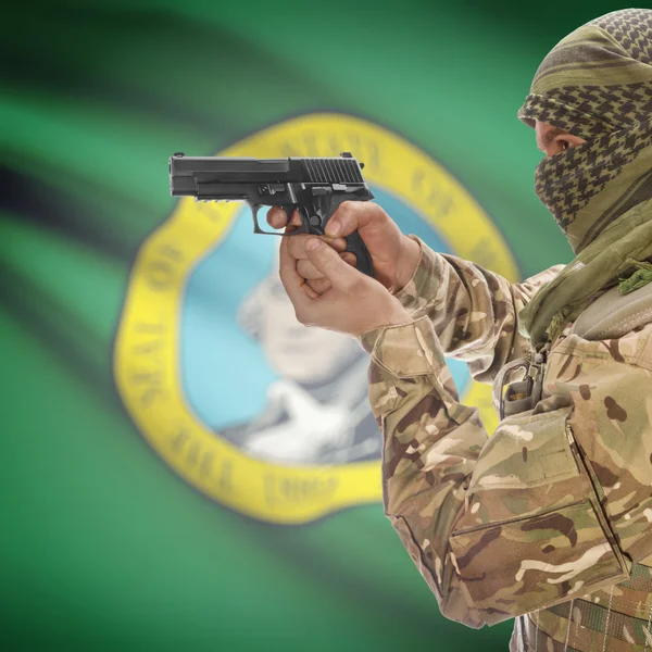 Мужчина с пистолетом в руках и государственный флаг США на фоне серии - Вашингтон — стоковое фото