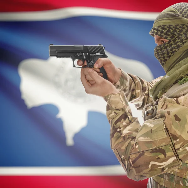 Male with gun in hands and USA state flag on background series - Wyoming — Stockfoto