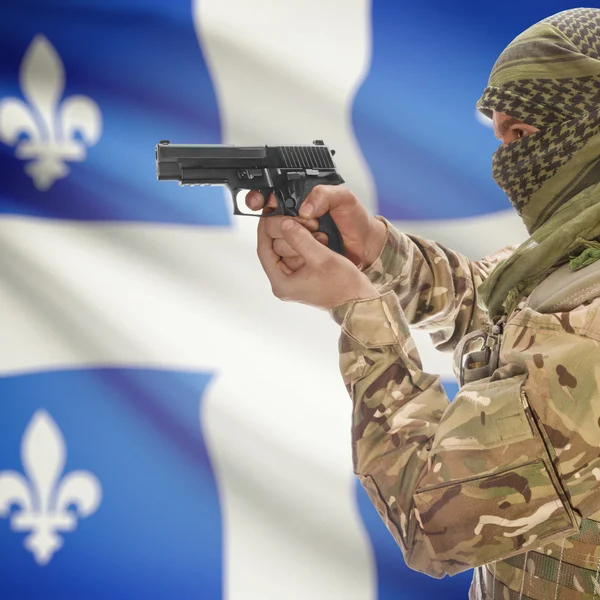 Man with gun in hand and Canadian province flad on background - Quebec