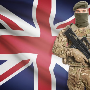 Soldier with machine gun and flag on background - United Kingdom of Great Britain