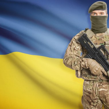 Soldier with machine gun and flag on background - Ukraine