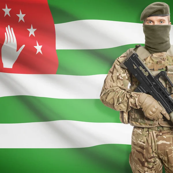Soldier with machine gun and flag on background - Abkhazia — Stok Foto