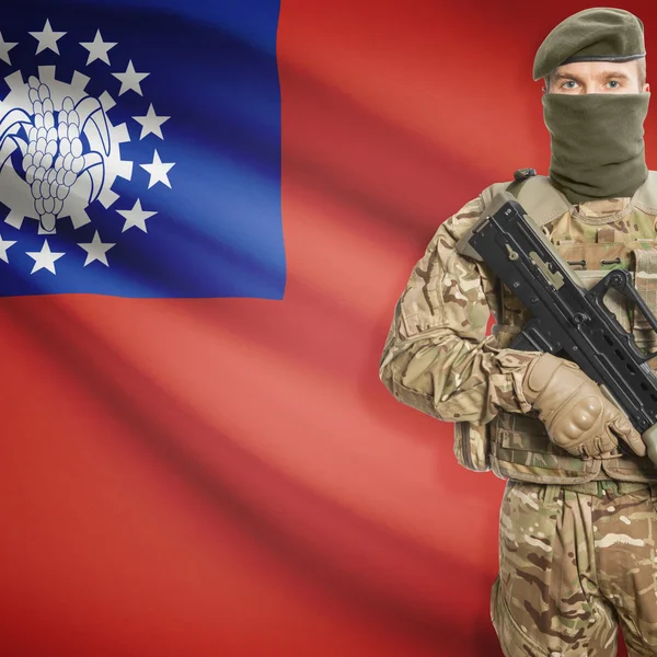 Soldier with machine gun and flag on background - Burma — Stock Photo, Image