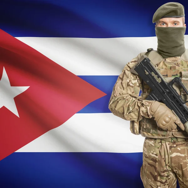 Soldier with machine gun and flag on background - Cuba – stockfoto