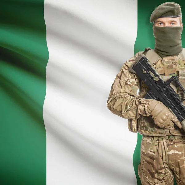 Soldier with machine gun and flag on background - Nigeria — Stok Foto