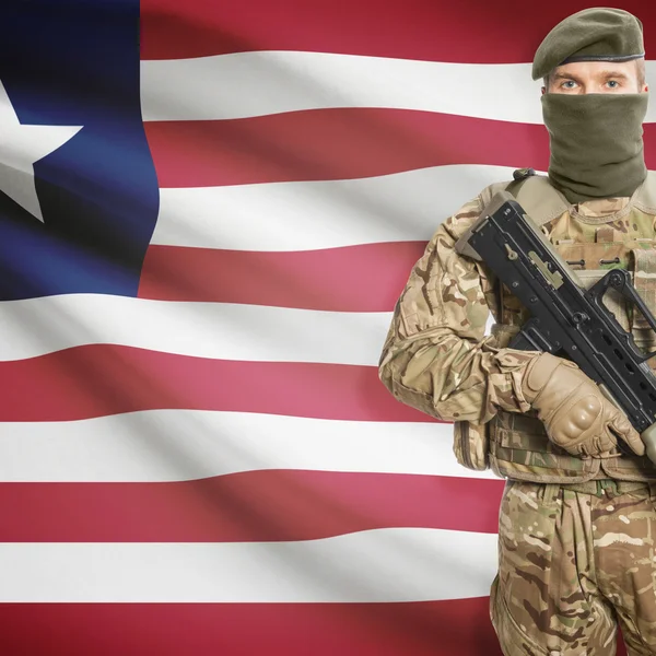 Soldier with machine gun and flag on background - Liberia — Stok Foto